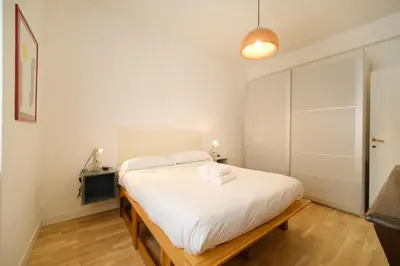 a bedroom with a large bed with white sheets at Blue Apartment Testaccio & Trastevere in Rome
