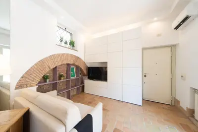a living room with white walls and a white couch at My Monti Charming Holiday Home in Rome