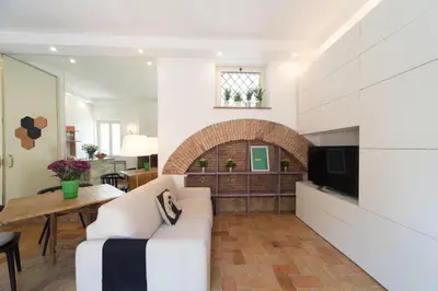 a living room with a white couch and a television at My Monti Charming Holiday Home in Rome