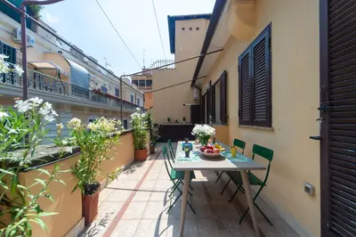 a table and chairs on the balcony of a building at My Monti Charming Holiday Home in Rome