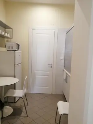 a kitchen with a white door and a table and chairs at Manrique home in Rome