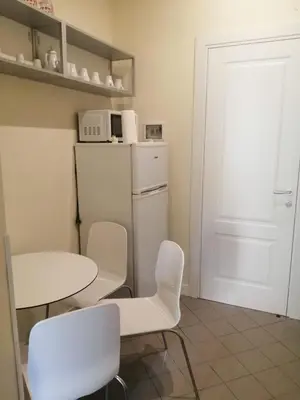 a kitchen with a table and chairs and a refrigerator at Manrique home in Rome