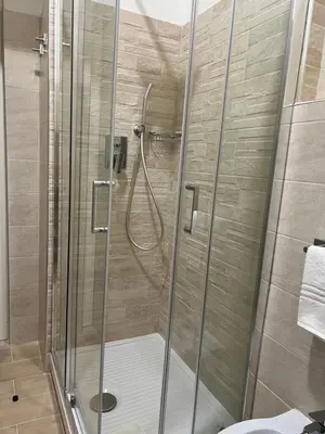 a shower with a glass door in a bathroom at Manrique home in Rome