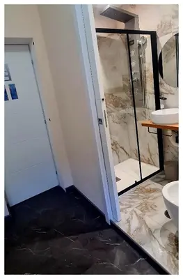 a bathroom with a shower and a toilet and a door at Wanderlust Suite in Rome