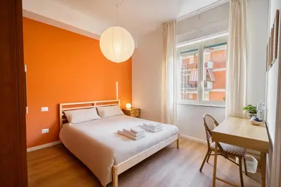 a bedroom with a bed and a desk and a window at Pigneto Mood Comfort nel Cuore Creativo di Roma in Rome