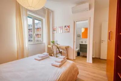 a bedroom with a bed and a desk and a window at Pigneto Mood Comfort nel Cuore Creativo di Roma in Rome