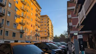 a row of cars parked in a parking lot next to buildings at Pigneto Mood Comfort nel Cuore Creativo di Roma in Rome