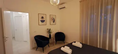 a bedroom with a bed and two chairs and a door at Casa Carmine in Rome