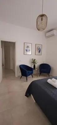 a bedroom with a bed and two blue chairs at Casa Carmine in Rome