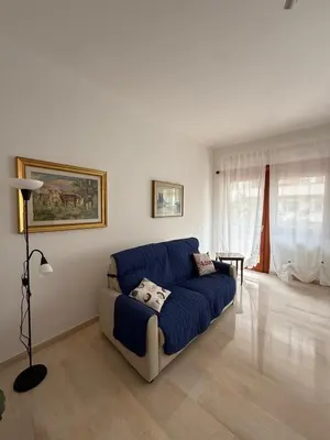 a living room with a blue couch and a table at Casa Verde Roma in Rome