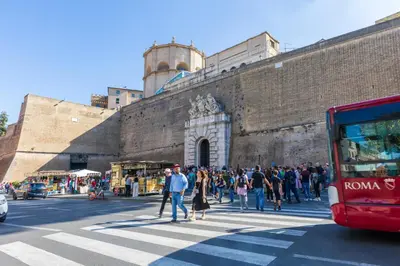 a crowd of people crossing a street in front of a building at Rome centre Vatican cozy apartment in Rome
