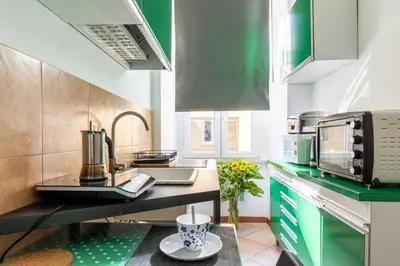 a kitchen with green cabinets and a counter top at Rome centre Vatican cozy apartment in Rome
