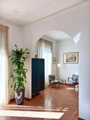 a living room with a green cabinet and a potted plant at Merulana 13 in Rome