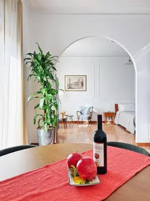 a bottle of wine sitting on a table with apples at Merulana 13 in Rome