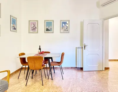 a dining room with a white table and chairs at Merulana 13 in Rome