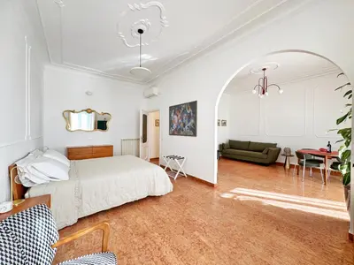 a bedroom with a bed and a living room at Merulana 13 in Rome