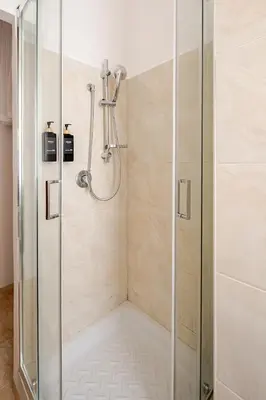 a shower with a glass door in a bathroom at Charming Well Connected New Studio - Asia Sleeps in Rome