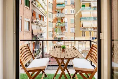 a balcony with a table and chairs and a view of a city at Charming Well Connected New Studio - Asia Sleeps in Rome
