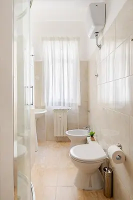 a white bathroom with a toilet and a sink at Charming Well Connected New Studio - Asia Sleeps in Rome