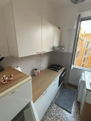 a small kitchen with white cabinets and a stove at Cozy Home Flaminio in Rome