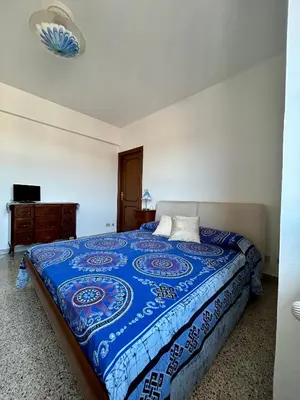 a bedroom with a bed with a blue comforter at Casa vacanze Morabito in Rome