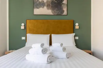 a pile of towels sitting on top of a bed at Hostly-San Paolo Charme Apartment in Rome