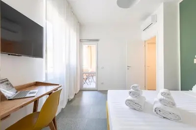 a bedroom with a bed and a desk with a laptop at Hostly-San Paolo Charme Apartment in Rome
