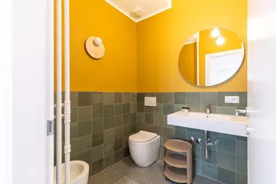 a bathroom with a sink and a toilet and a mirror at Hostly-San Paolo Charme Apartment in Rome