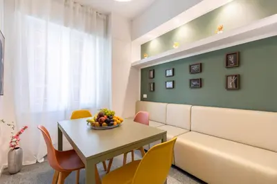 a living room with a couch and a table and chairs at Hostly-San Paolo Charme Apartment in Rome