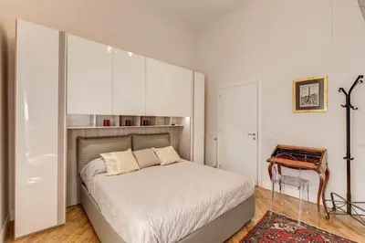 a white bedroom with a bed and a table at Casa Claudia Giulio Cesare in Rome