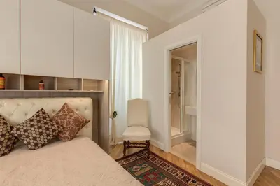 a bedroom with a large bed and a chair at Casa Claudia Giulio Cesare in Rome
