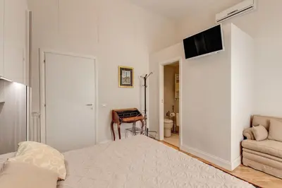 a bedroom with a bed and a television on a wall at Casa Claudia Giulio Cesare in Rome