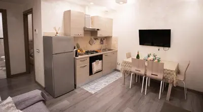 a kitchen with a refrigerator and a table with chairs at Monteverde Charme -ROMA- in Rome