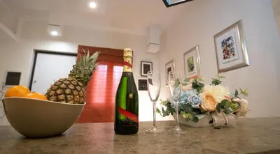 a bottle of champagne and a bowl of fruit and a bowl of pineapple at Monteverde Suite -ROMA- in Rome