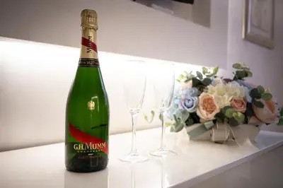 a green bottle of champagne next to two wine glasses at Monteverde Suite -ROMA- in Rome