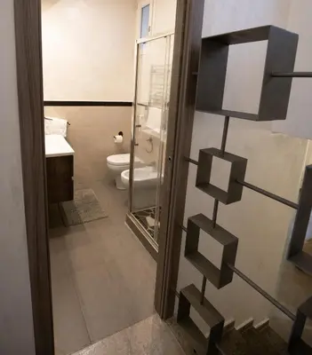 a bathroom with a toilet and a glass door at Monteverde Suite -ROMA- in Rome
