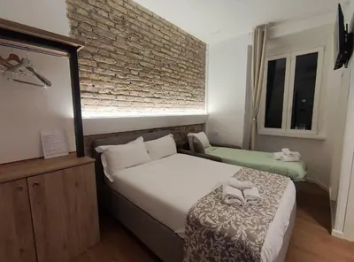 a bedroom with two beds and a brick wall at Castle Suite Borgo in Rome