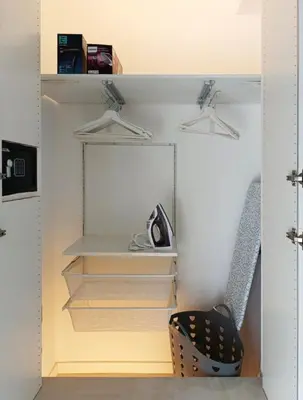 a closet with white shelves and a chair at TraStella, Trastevere di charme, balcone & hammam in Rome