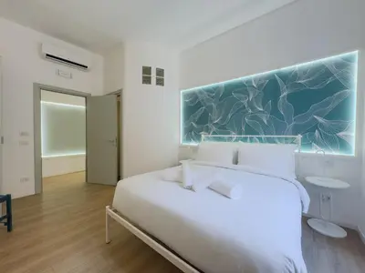 a bedroom with a white bed with a painting on the wall at Santamaura Vacanze Vaticane Elegance e Comfort in Rome
