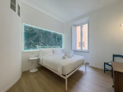 a bedroom with a large white bed and a glass door at Santamaura Vacanze Vaticane Elegance e Comfort in Rome