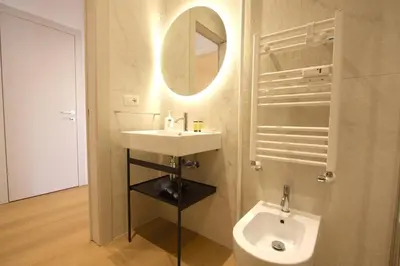a bathroom with a sink and a toilet and a mirror at Claudia 2BR Holiday Home in Rome