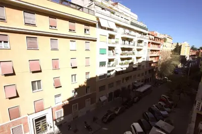 an apartment building with cars parked in a parking lot at Claudia 2BR Holiday Home in Rome