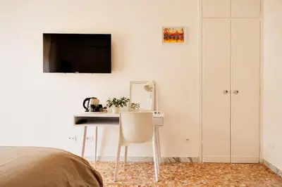 a bedroom with a desk and a tv on the wall at Geppy Vacation home near Saint Peter Basilica in Rome