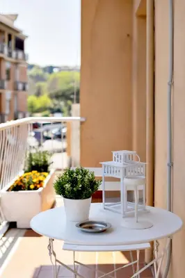 a white table on a balcony with a plant at Geppy Vacation home near Saint Peter Basilica in Rome
