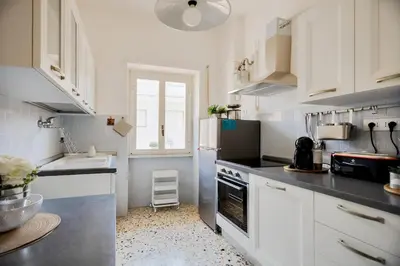a kitchen with white cabinets and a sink and a refrigerator at Geppy Vacation home near Saint Peter Basilica in Rome