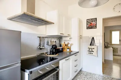 a kitchen with white cabinets and a black counter top at Geppy Vacation home near Saint Peter Basilica in Rome