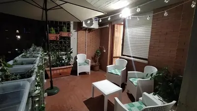 a room with plants and white chairs and an umbrella at Domus Piscariae in Rome