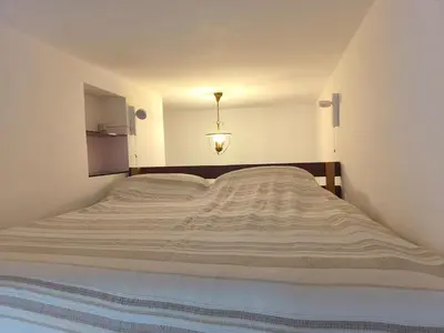 a large bed in a white bedroom with a light at Apartment Sora Marcella, Testaccio in Rome