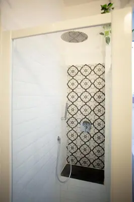 a white tiled bathroom with a toilet in it at Apartment Sora Marcella, Testaccio in Rome