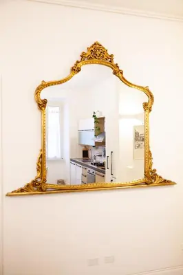 an ornate gold mirror hanging on a wall at Apartment Sora Marcella, Testaccio in Rome